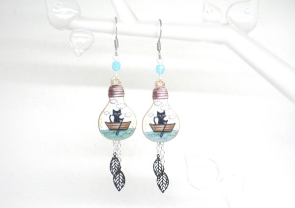 Boucles d'oreilles ampoules électriques avec chats noirs sur leur barque nuages perles feuilles noir doré blanc bleu lagon argenté par Odacassie les créations de Cassandre bijoux et accessoires faits main bijoux poétiques bijoux bohèmes bijoux romantiques idée cadeau femme