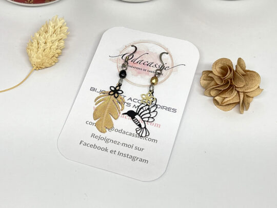 Boucles d'oreilles asymétriques plume oiseau fleurs et perles tons doré et noir acier inoxydable par Odacassie