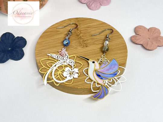 Boucles d'oreilles colibris sur fleurs asymétriques tons doré blanc rose mauve bleu pastel par Odacassie